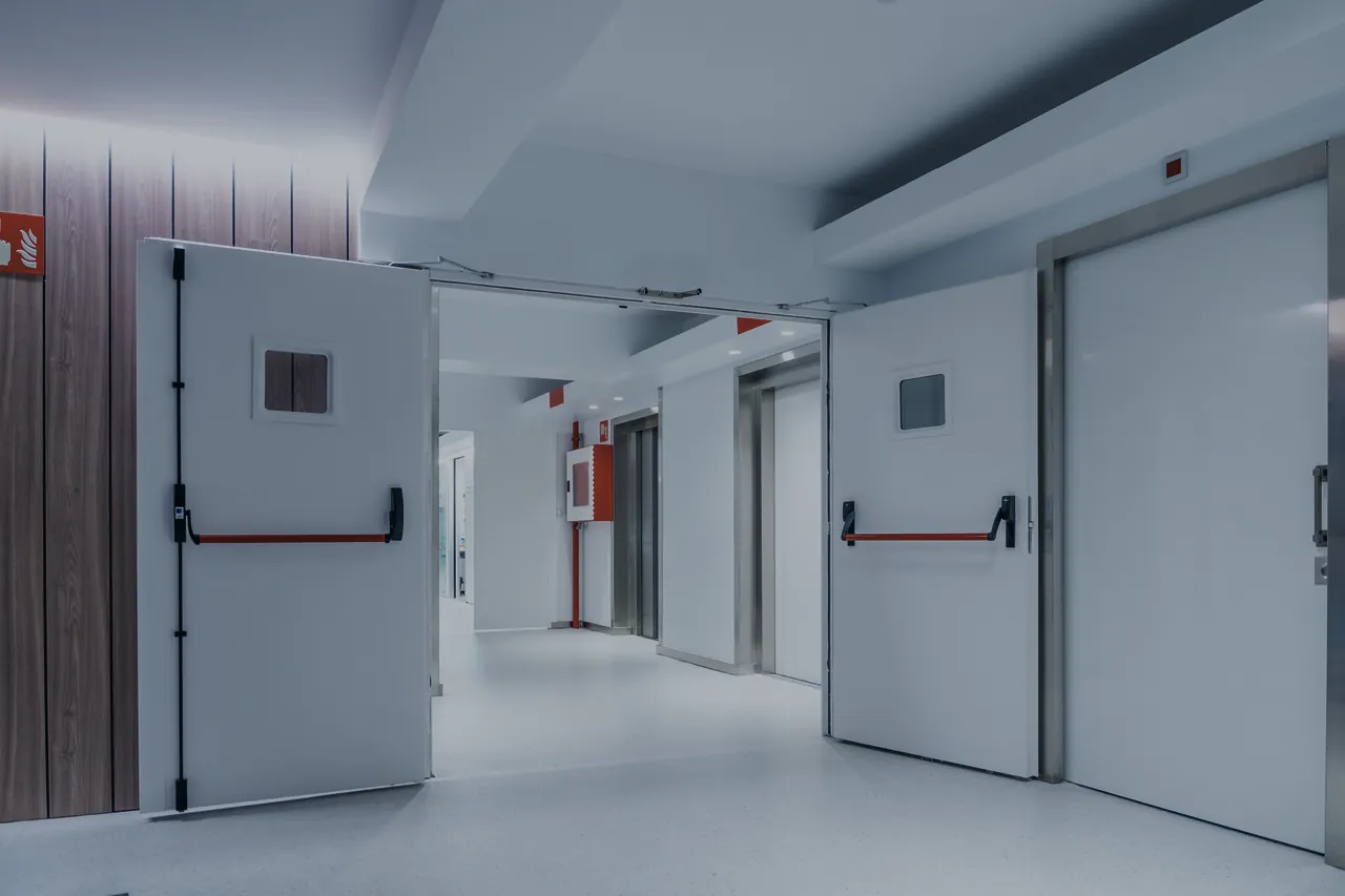 Couloir d’établissement avec portes coupe-feu à double vantail et barres anti-panique