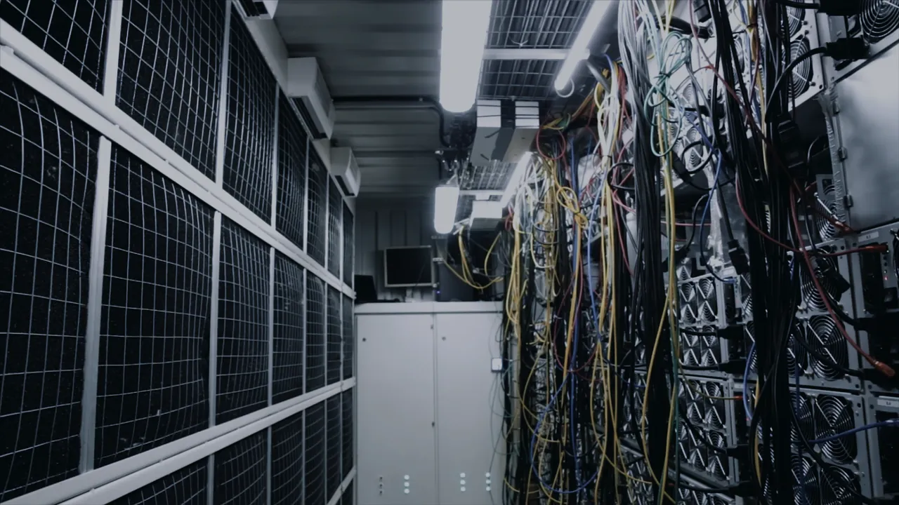Allée de baies informatiques et faisceaux de câbles dans un datacenter